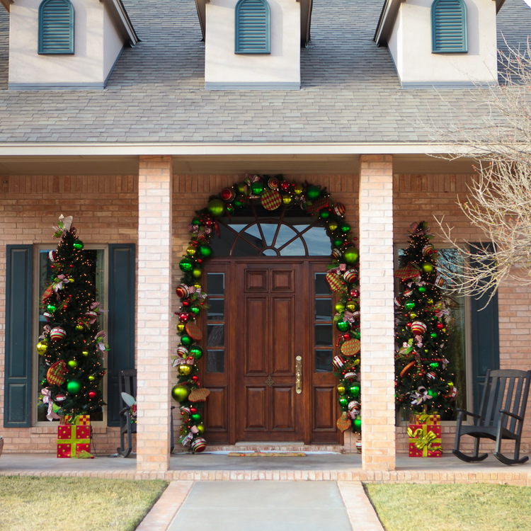 Mesmerezing Front Porch Decorating For Christmas By Colorfull Balls On The Brick Wall With Brown Wooden Door On The Middle Also Twin Christmas Tree