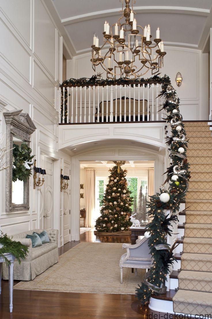 A noble fir is an immediate presence inside this grand entry. Exquisite garland graces the banister.