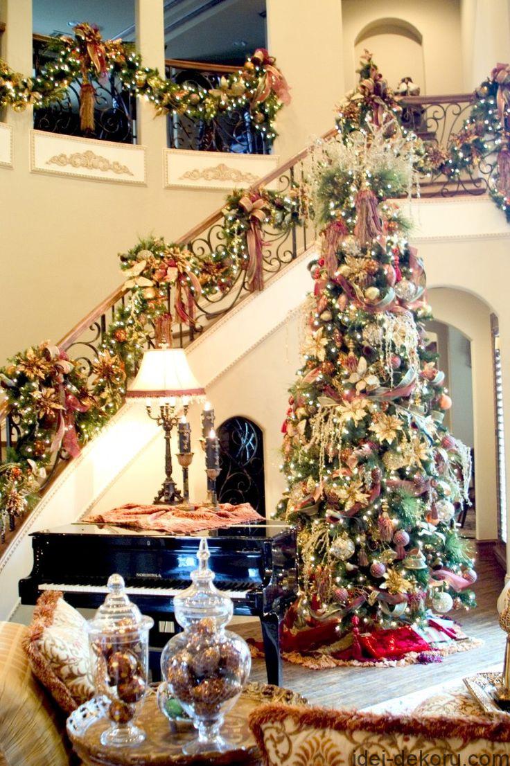 Amazing luxurious Christmas decoration with elegant high Christmas tree filled with lots of beautiful ornaments and stunning staircase handrails decor.