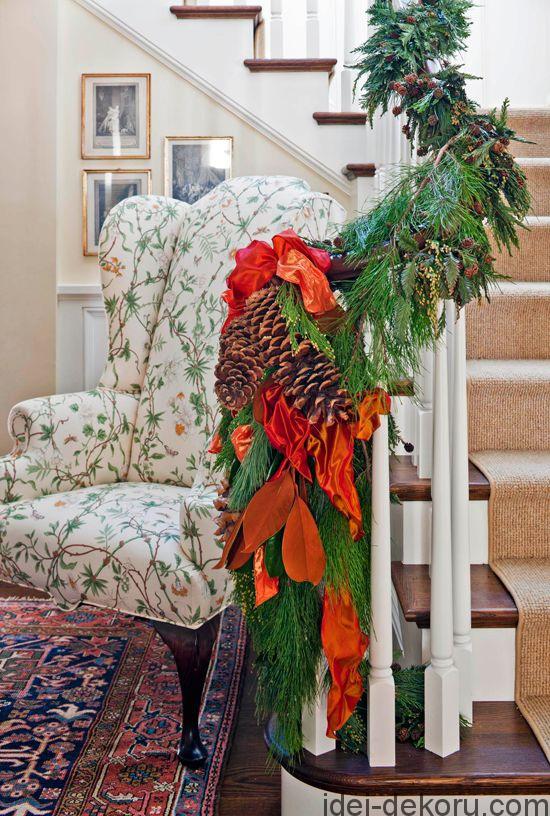 Large pinecones tied with bright ribbon cap off a banister garland. - Traditional Home ® / Photo: John Granen / Design: Elizabeth Hague