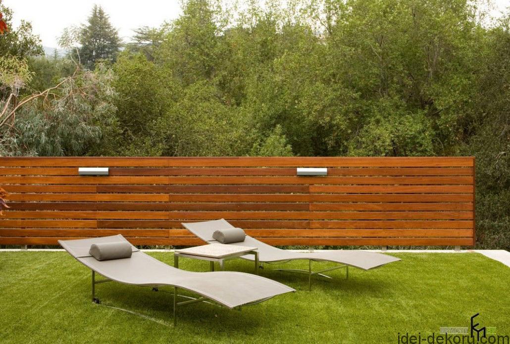 a-stunnig-striking-wooden-fencing-with-grassy-backyard-and-modern-easychairs-for-sunbathing