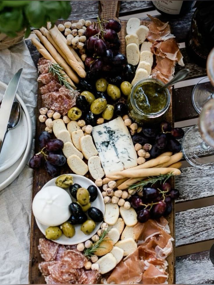  м'ясо-сирна тарілка (charcuterie board) з різними видами сиру, м'яса, фруктів та горіхів.